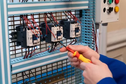 Un jeune en BAC PRO MELEC en train de travailler sur un cheminement de câbles