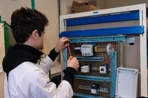 Jeune en train de travailler sur son plateau technique électricité