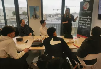 Jeune autour d'une table écoutant une formatrice