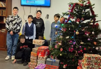 Jeunes devant le sapin de Noel , ils tiennent des cadeaux