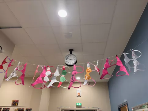 Soutiens-gorges en papier suspendus sur un fil