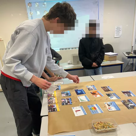 Lycéen dispose des cartes de la Fresque Numérique sur une table