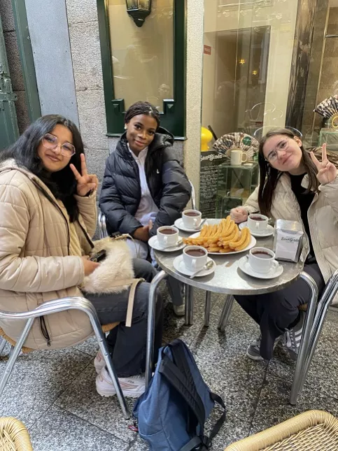 Jeunes filles attablés dans un café en train de manger des churros