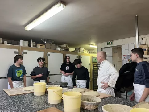 Jeunes avec le boulanger, ils préparent la pâte à pain
