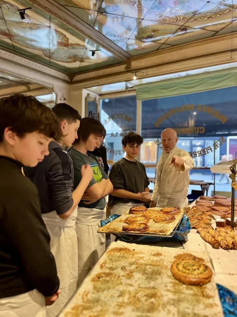 Jeunes dans la boulangerie devant les pains et viennoiseries sortis du four