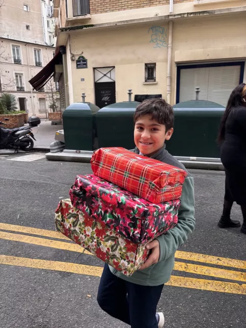 Jeune garçon avec des cadeaux dans les bras