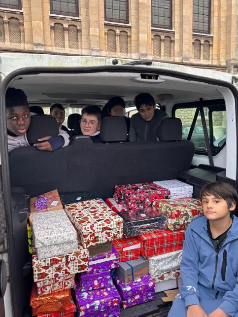 Jeune devant la voiture pleine de cadeaux
