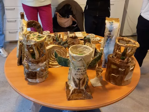Exposition sur une table des trophées en argile crées par les élèves