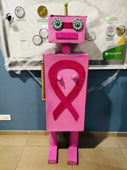 Oeuvre artistique rose représentant un robot portant un ruban rose