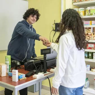 Jeune vendeur qui rend la monnaire à la caisse d'un magasin
